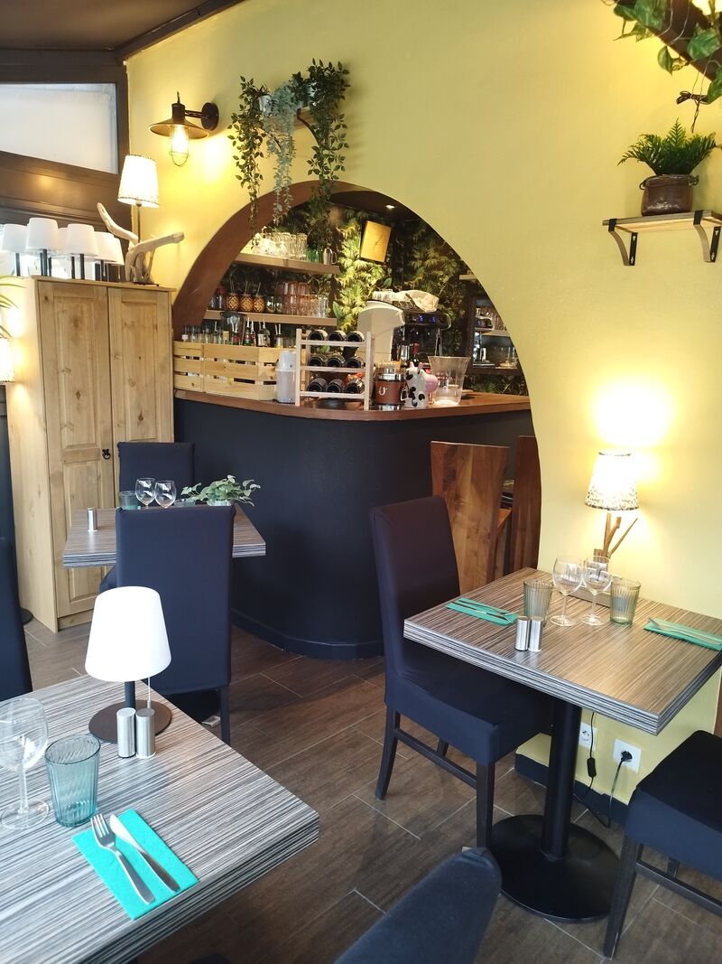Salle voûtée du Onze : mur curry, bar bleu nuit, mur végétal et déco bohème tamisée